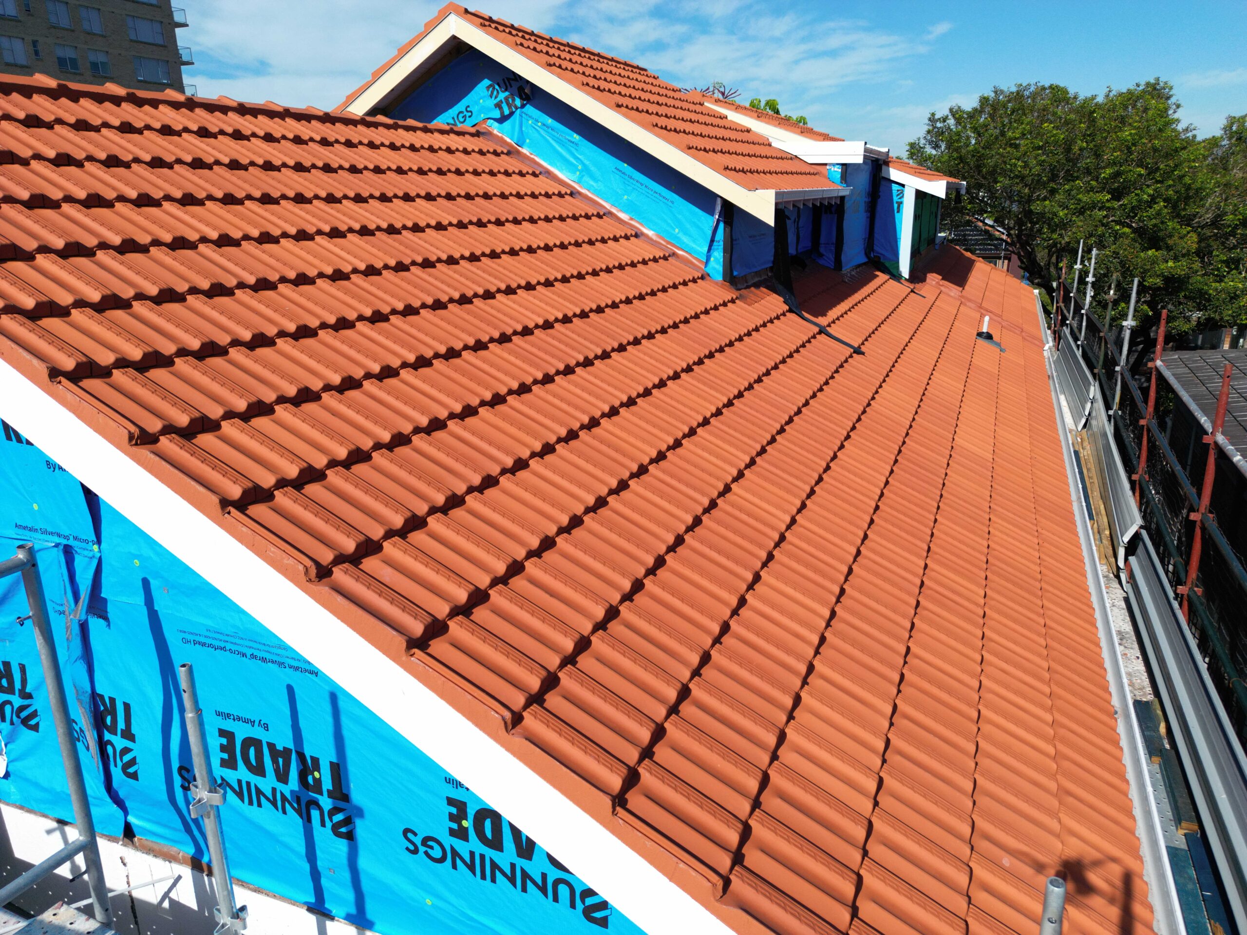 New orange terracotta tiles on a pitched residential roof, a professional Tile Roof Repair Sydney installation.